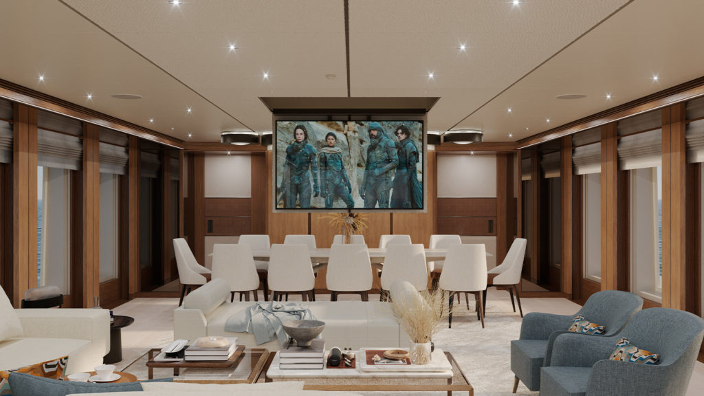 Luxurious yacht interior featuring a large screen showing a movie, surrounded by comfortable seating and a long dining table with white chairs.