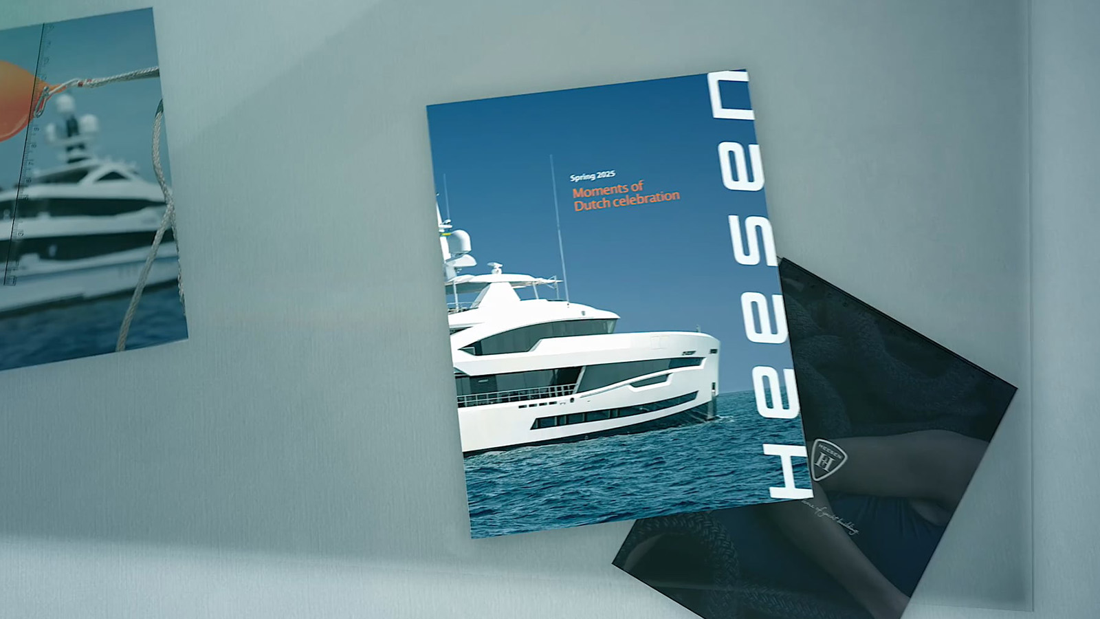 A magazine cover featuring a large white yacht on the ocean under a clear blue sky, titled "Spring 2025 Moments of Dutch Celebration," with the name "Heesen" vertically across the side.