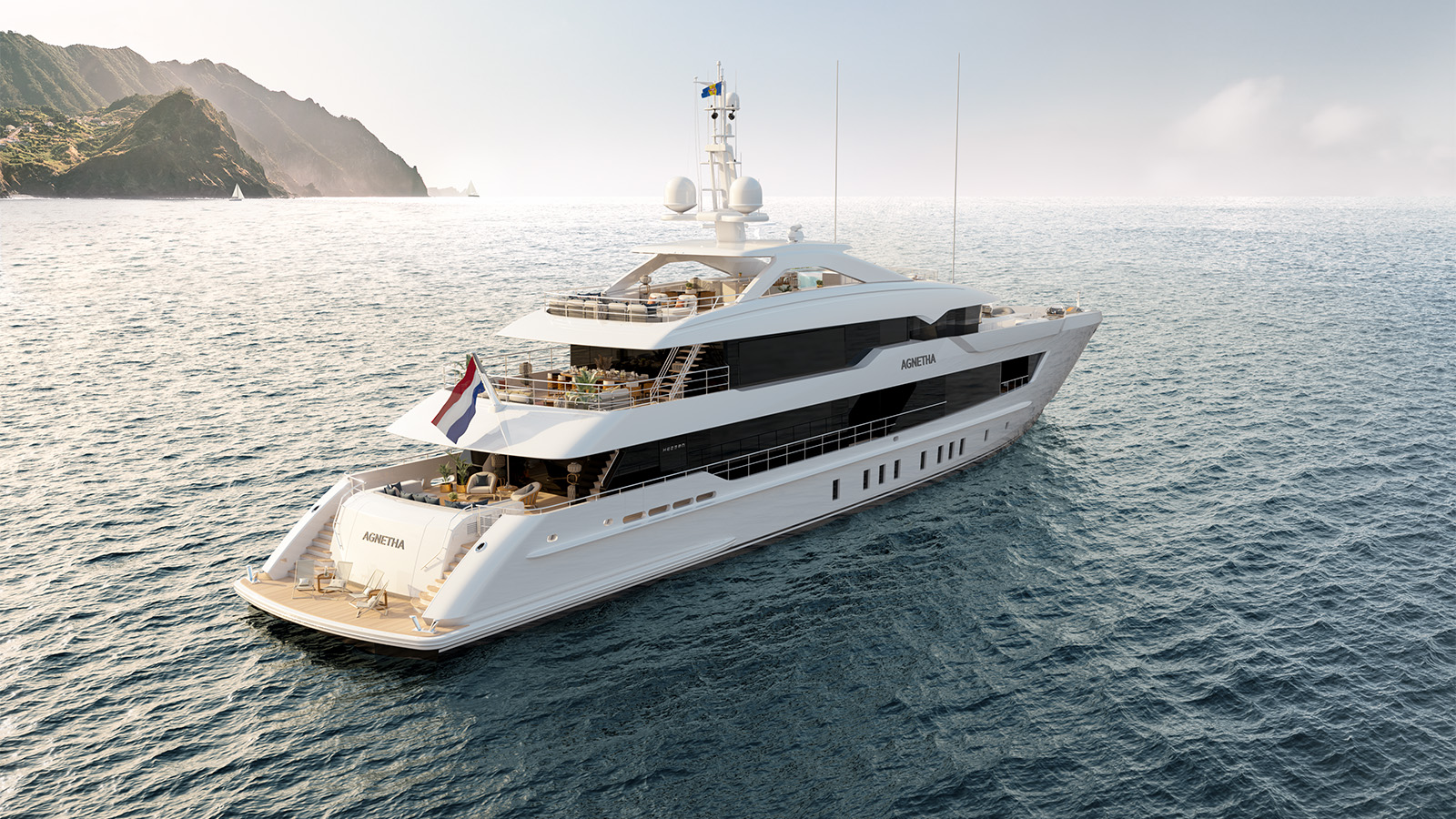 Luxurious white yacht named 'Agnetha' cruising in calm ocean waters, with a mountainous coastline visible in the background.