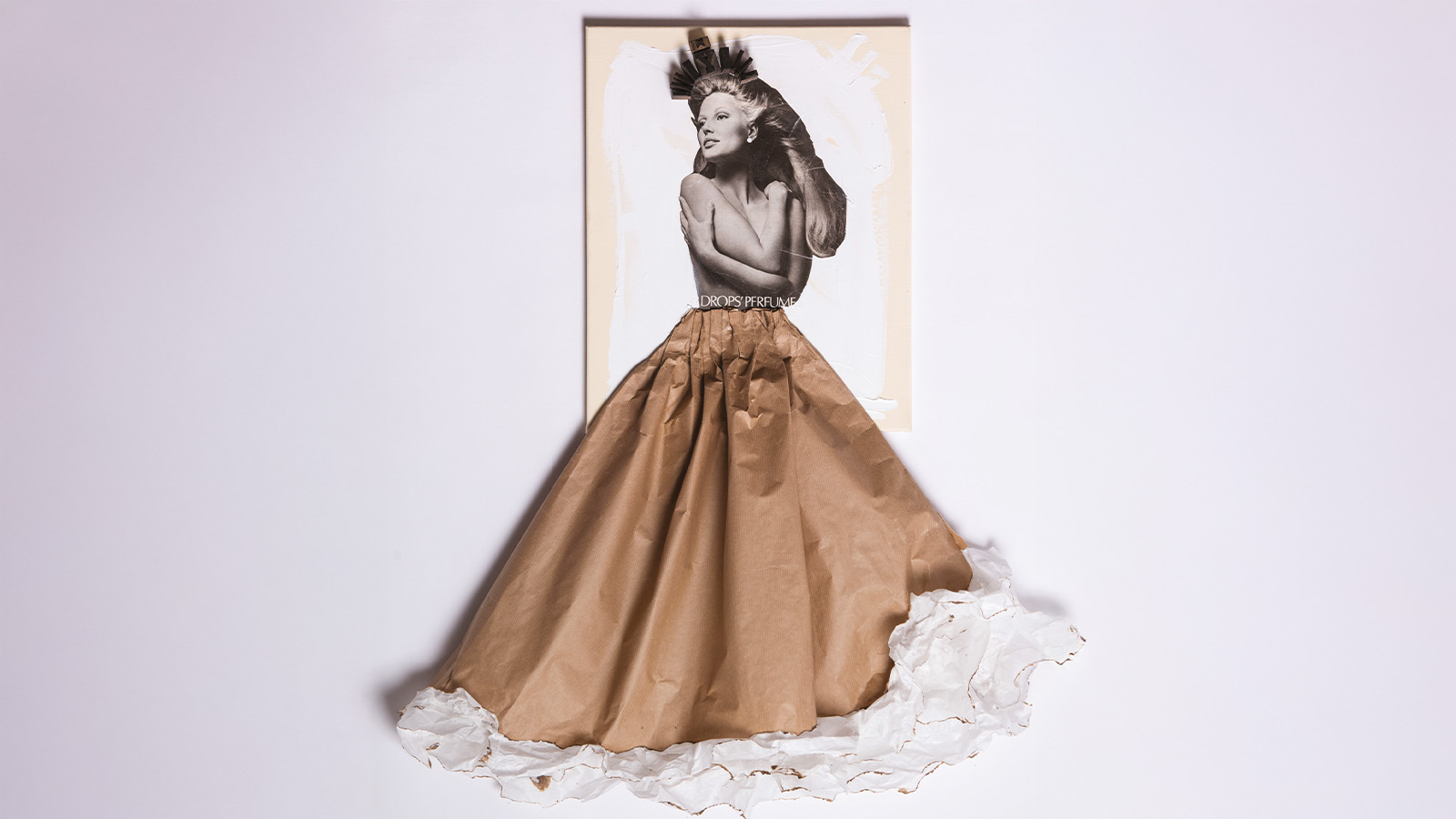 A collage artwork featuring a black and white photograph of a woman from the waist up. Her lower half is creatively extended with a skirt made from crumpled brown and white paper, forming an elegant dress shape.